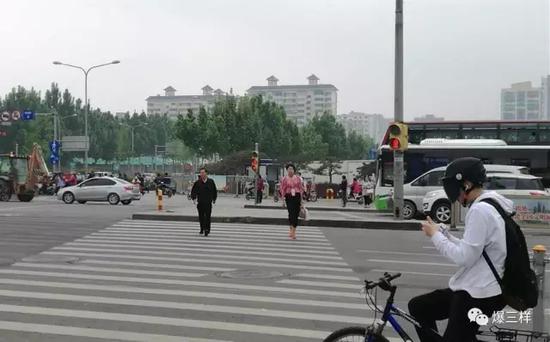 　　早高峰時段，濟南經(jīng)十路和諧廣場路口，兩位市民闖紅燈過馬路