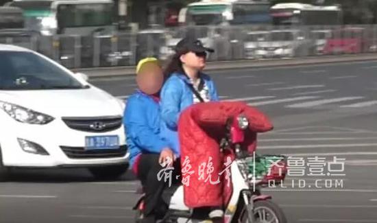 17日,经十路纬一路,一位女士带着孩子骑电动车闯红灯。