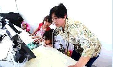 曹桂英正在指导孩子们上计算机课。