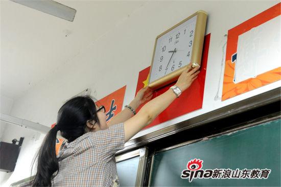 吴新颖老师将检查完毕的钟表悬挂在考场教室讲台正上方。 吴新颖老师将检查完毕的钟表悬挂在考场教室讲台正上方。