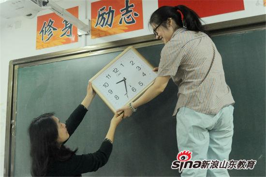 王志会、吴新颖两位监考老师整理考场,检查钟表运行情况,更换新电池。 王志会、吴新颖两位监考老师整理考场,检查钟表运行情况,更换新电池。