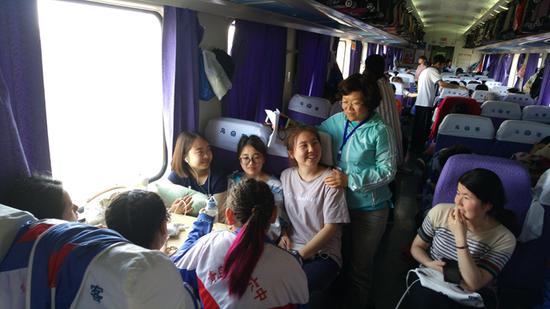 　　哈热西（中）和老师同学们在回家的火车上
