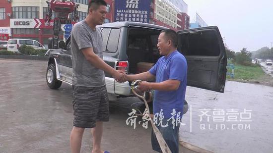 此时,有一辆小箱货被困。队员大山及时将其拖出水中,司机激动地与他握手,向队员表示感谢。