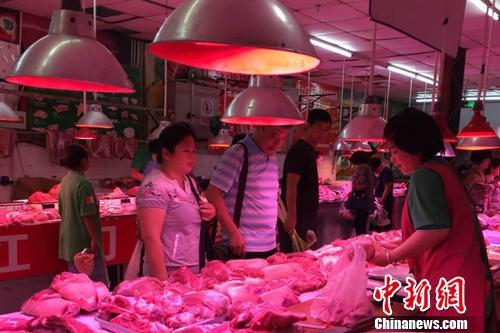 　　北京陶然亭公园附近一家农贸市场内，正有消费者在挑选五花肉。中新网 种卿 摄
