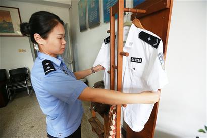 同事將崔建武身前穿的警服整理好,掛在辦公室里。(記者 樊蓉 攝)