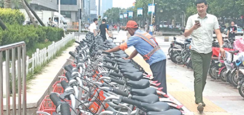 单车管理员将停车场内的单车摆放整齐。
