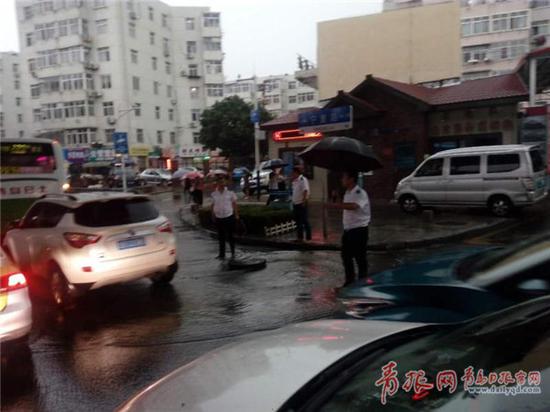 工作人員冒雨上街當起了人肉“警示牌”
