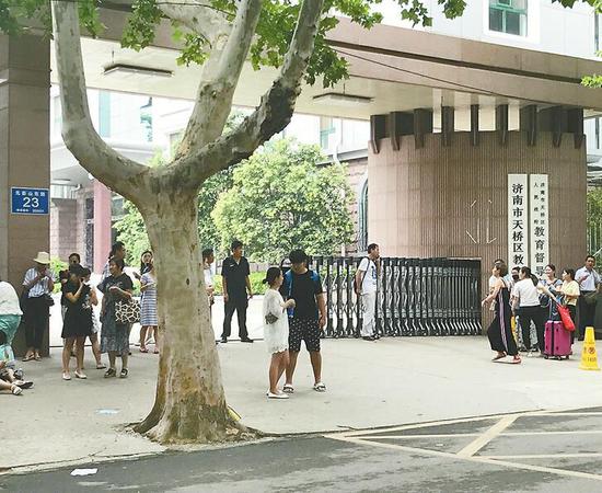 　　24日午休时间，仍有不少考生等在门前。 记者俞丹 摄