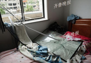 (事故酒店对面紫薇园的住户吴女士家北边卧室整个窗户被掀掉。齐鲁晚报·齐鲁壹点记者 戴伟 摄)