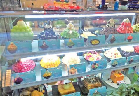 　　世茂广场一家甜品店内， 搭配了芒果、 西瓜、 沙冰的甜品种类丰富。