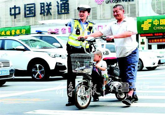 张宵引导非机动车有序通行。齐鲁晚报·齐鲁壹点 记者 张泰来 摄