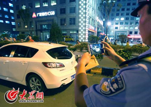 市中区交警在万达广场附近对违停车辆进行现场取证处罚