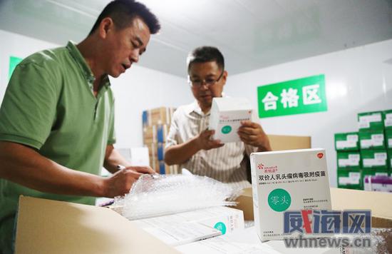 在冷藏庫內,工作人員現場核查疫苗批次編號