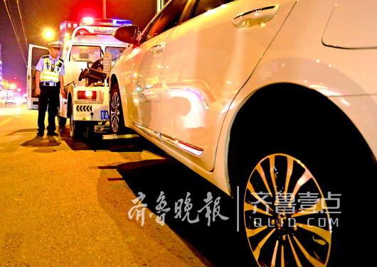 8月8日晚,濟南市中交警夜間查違停,一輛違停車被強制拖離。 市中交警供圖