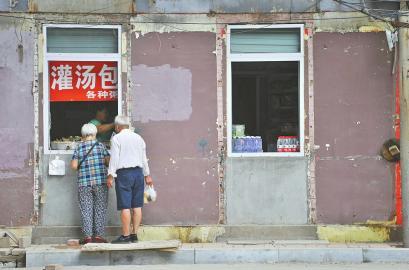 8月20日，胜利大街居民楼下个别小吃店封闭了大门，只留半扇窗户营业。