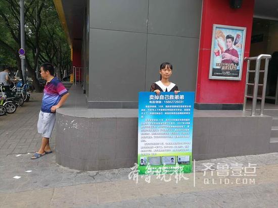 在街头举牌“卖身”的李晓晓，旁边是她父亲。