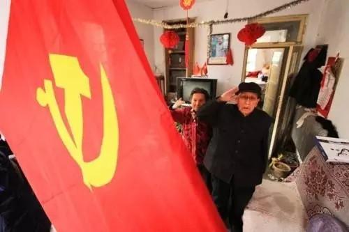 殷樹山、劉彩鳳夫婦向黨旗敬禮(資料圖)