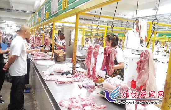 在南下河市场，市民们在挑选猪肉。