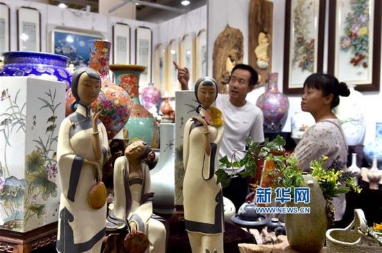 8月26日,市民在第五屆濟南藝術博覽會上欣賞陶瓷作品。