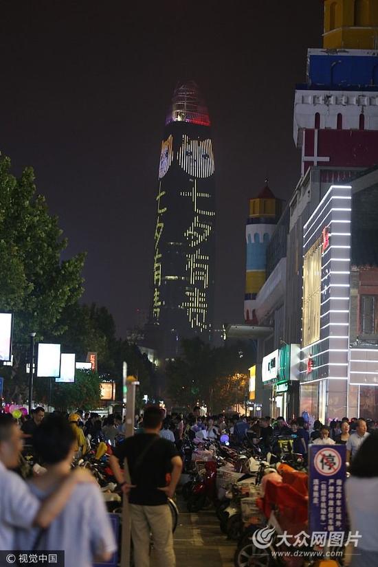 8月28日，濟南第一高樓，一面亮“關愛汪星人 七夕有責”字樣“一面亮多人恩愛字樣，讓單身朋友又愛又恨。