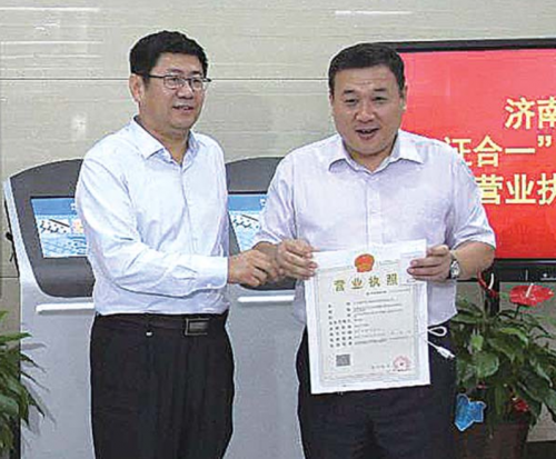 济南市工商局局长王建森给企业颁发省内首张“三十一证合一”营业执照。