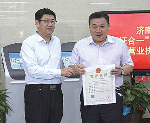 濟南市工商局局長王建森給企業頒發省內首張“三十一證合一”營業執照。