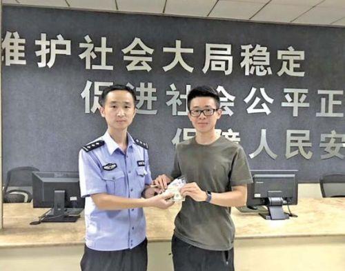 李骜从民警手中接过了自己丢失的钱包。 见习记者 刘晓 摄