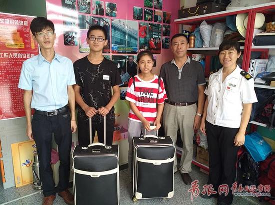兩位新生在車(chē)站工作人員幫助下順利找回各自的行李箱