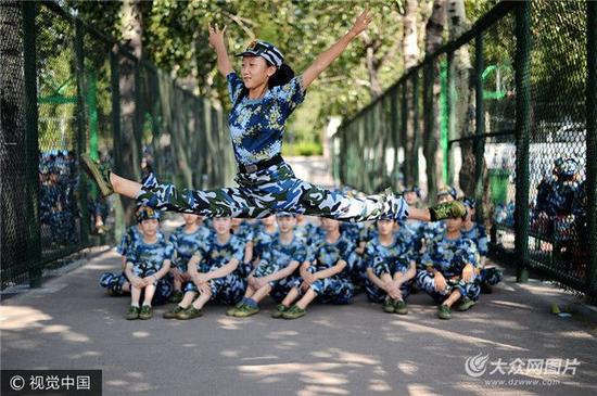 音乐学院舞蹈专业的十几名女生利用休息时间，相互比拼舞蹈技能，向师生展示一字马、大跳等优美舞姿，为军训生活增添一份活力。
