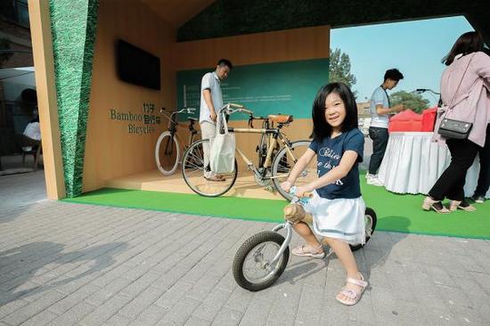 9月3日，北京99公益日市集上，小朋友在试骑竹子自行车儿童款。