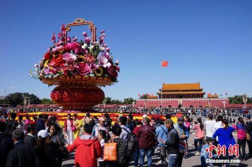 资料图：国庆假期首日，大量游客在天安门广场拍照留念。中新社记者 侯宇 摄