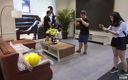 現場不少參觀者誤以為熟睡在展品沙發上的工人是一名模特,上演了一場行為藝術,紛紛拿出手機拍照留影。