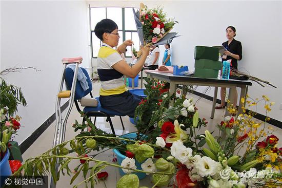 參賽殘疾人在進行插花項目的比賽。