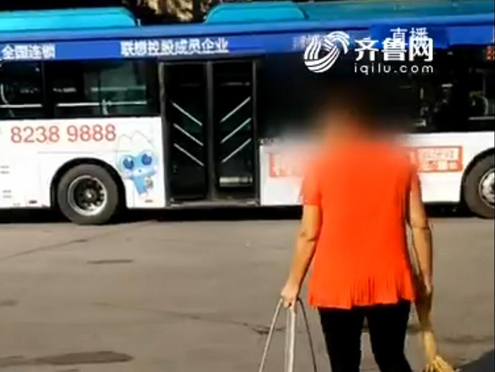 记者从现场视频看到，这名女子只顾手里的扫帚，并没有认真回答车队工作人员的问题。