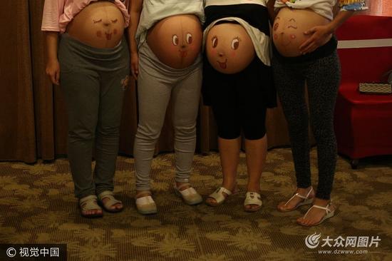 山东潍坊，十几位准妈妈为迎接宝宝降生，在一彩绘现场由准爸爸们亲手描绘肚皮彩绘，“孕”味十足。