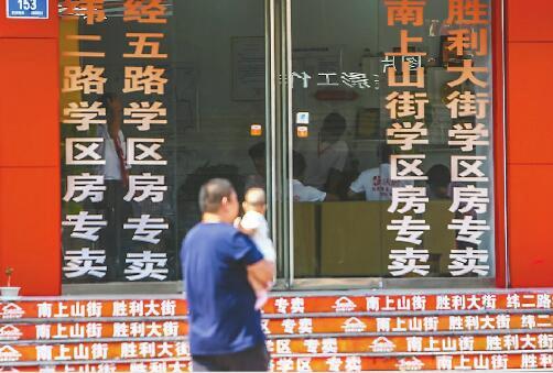在纬一路附近,许多房产中介将学区房信息作为主打广告。记者黄中明 摄
