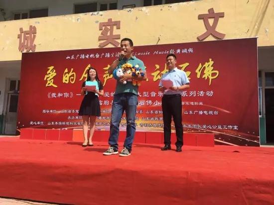 山东牛牛团队的负责人金牛先生和爱心人士一起为孩子们送上玩具布娃娃。