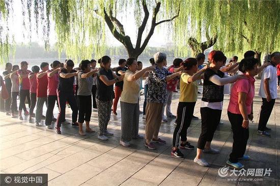 2017年9月20日清晨，在山東濟(jì)南大明湖景區(qū)內(nèi)，數(shù)百大爺大媽互相拍打肩膀跳操，幽默滑稽的體育動作，逗笑不少過往游客。