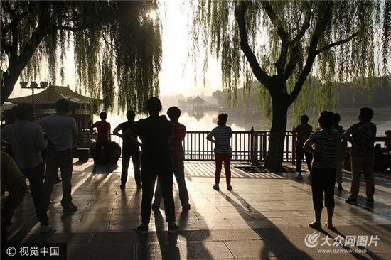 2017年9月20日清晨，在山东济南大明湖景区内，数百大爷大妈互相拍打肩膀跳操，幽默滑稽的体育动作，逗笑不少过往游客。