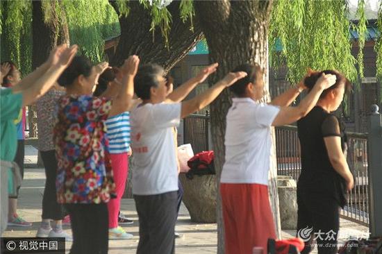 2017年9月20日清晨，在山东济南大明湖景区内，数百大爷大妈互相拍打肩膀跳操，幽默滑稽的体育动作，逗笑不少过往游客。