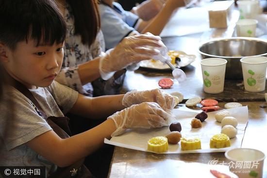 9月24日，濟南，來自山東師范大學附屬小學一年級六班的孩子們，與父母一同體驗制作手工冰皮月餅，感受傳統文化。