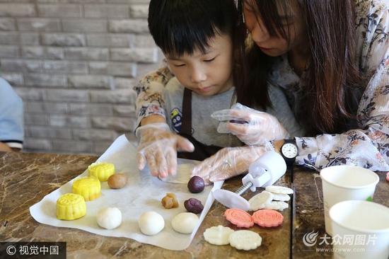 9月24日，济南，来自山东师范大学附属小学一年级六班的孩子们，与父母一同体验制作手工冰皮月饼，感受传统文化。