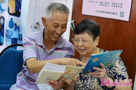 9月26日,青島市30名老人與祖國同慶生日。圖為鄰里之間通過家庭相冊回憶了家與國息息相關的發展歷程。
