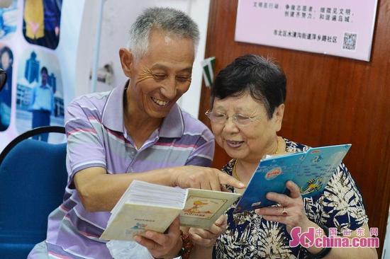 9月26日，青岛市30名老人与祖国同庆生日。图为邻里之间通过家庭相册回忆了家与国息息相关的发展历程。