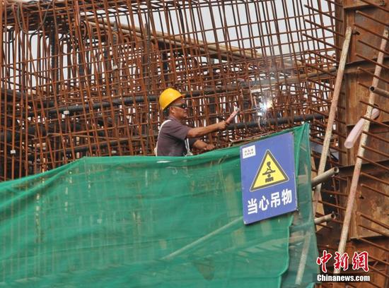 10月1日，建设者在四川眉山市东坡区岷江一桥改造工程施工现场忙碌。姚永亮 摄