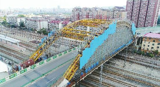 7日，顺河高架跨胶济铁路桥已搭建起密密麻麻的脚手架和保护隔离板。 首席记者王锋 摄