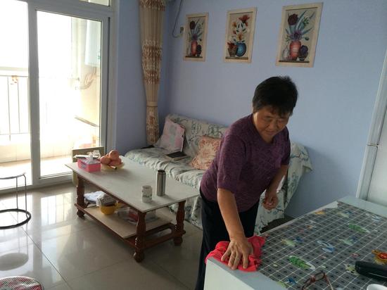 62歲的彭桂芳正在收拾著房子。