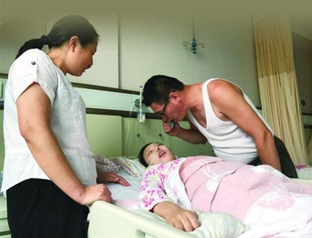 在病房里，刘英新用口琴为沉睡中的女儿吹了一曲《欢乐颂》，希望欢快的曲调能感染到她，以期孩子早日醒来 记者 陈晨摄