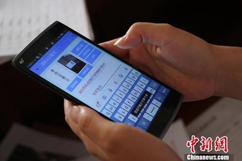 资料图：浙江台州推出租房“旅馆式”管理。8月9日，台州一位网格员正在利用手机对租客进行身份信息确认。中新社记者 王刚 摄