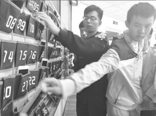 上課前,同學(xué)們將手機放在教室前的收納袋中。記者尹明亮 攝